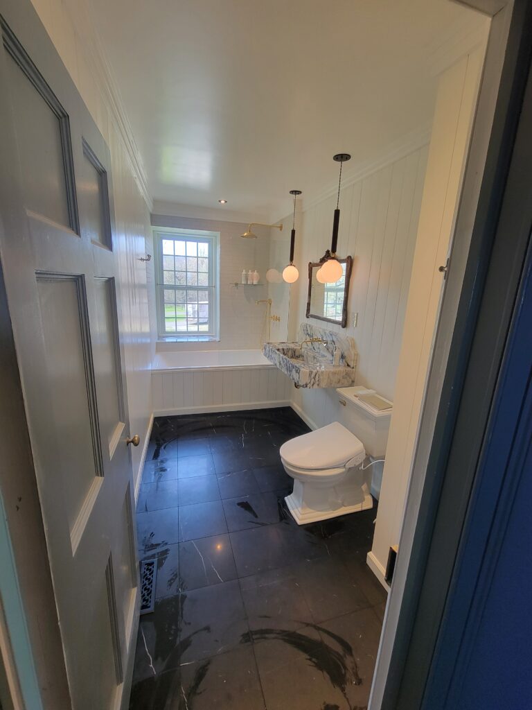Completed bathroom with custom stone vanity and freestanding tub