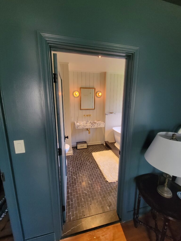 View into a completed bathroom with freestanding tub and stone floor
