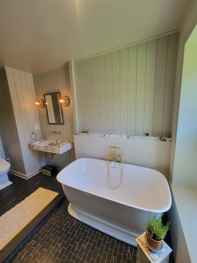 Freestanding tub with custom wall tile and brass fixtures