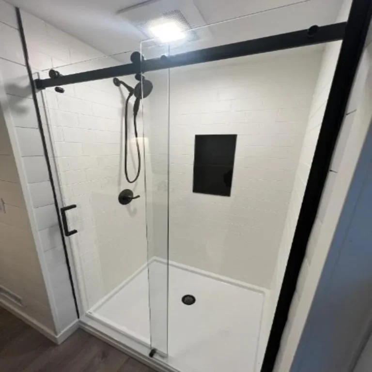 Low-threshold white shower with black-framed sliding door