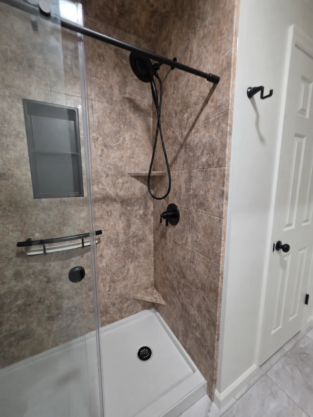 Matte-black controls and handheld shower in the finished MDR acrylic shower in Selkirk