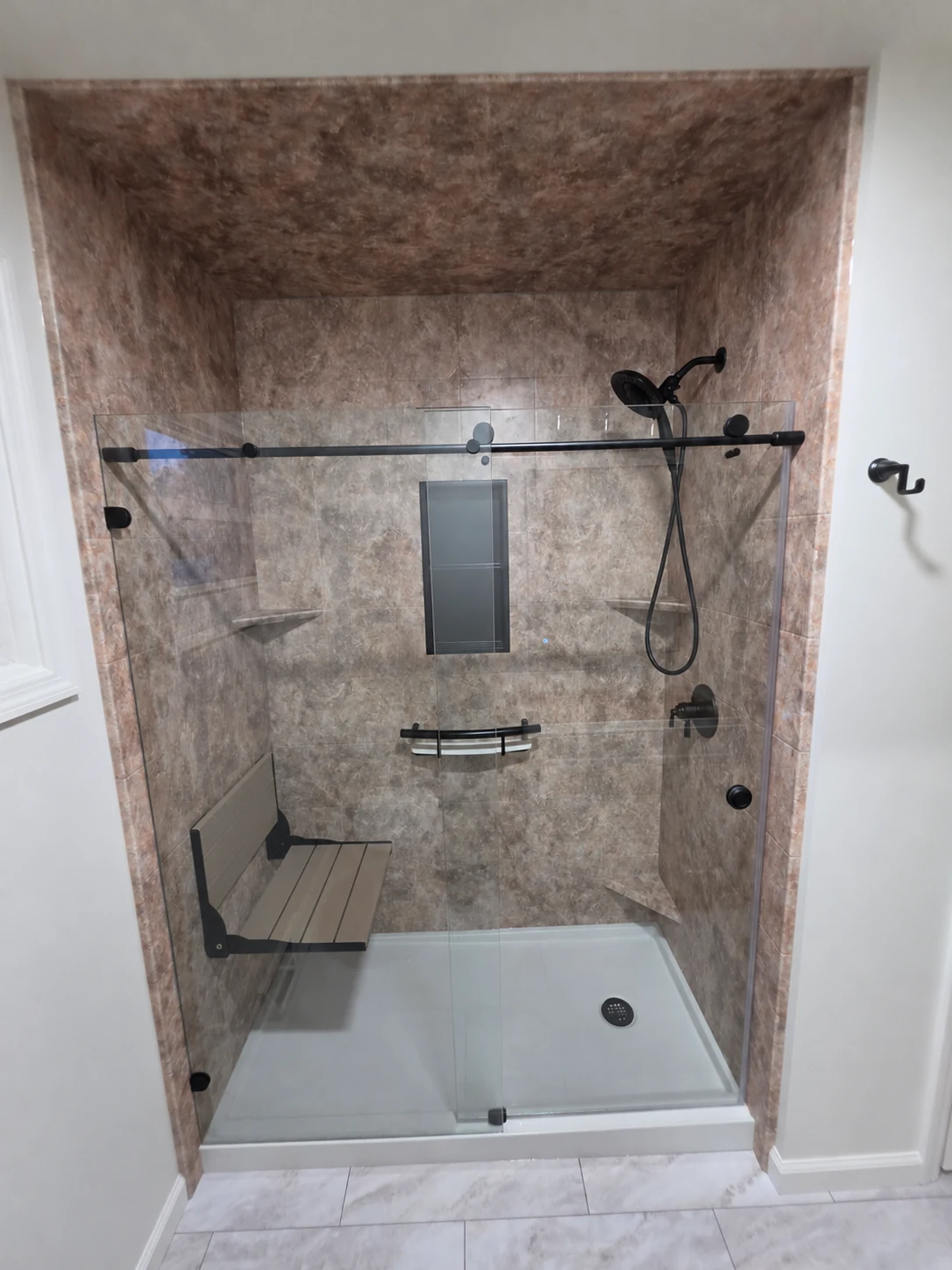 Completed Moore Done Right acrylic shower in Selkirk with glass doors, fold-down seat and handheld shower